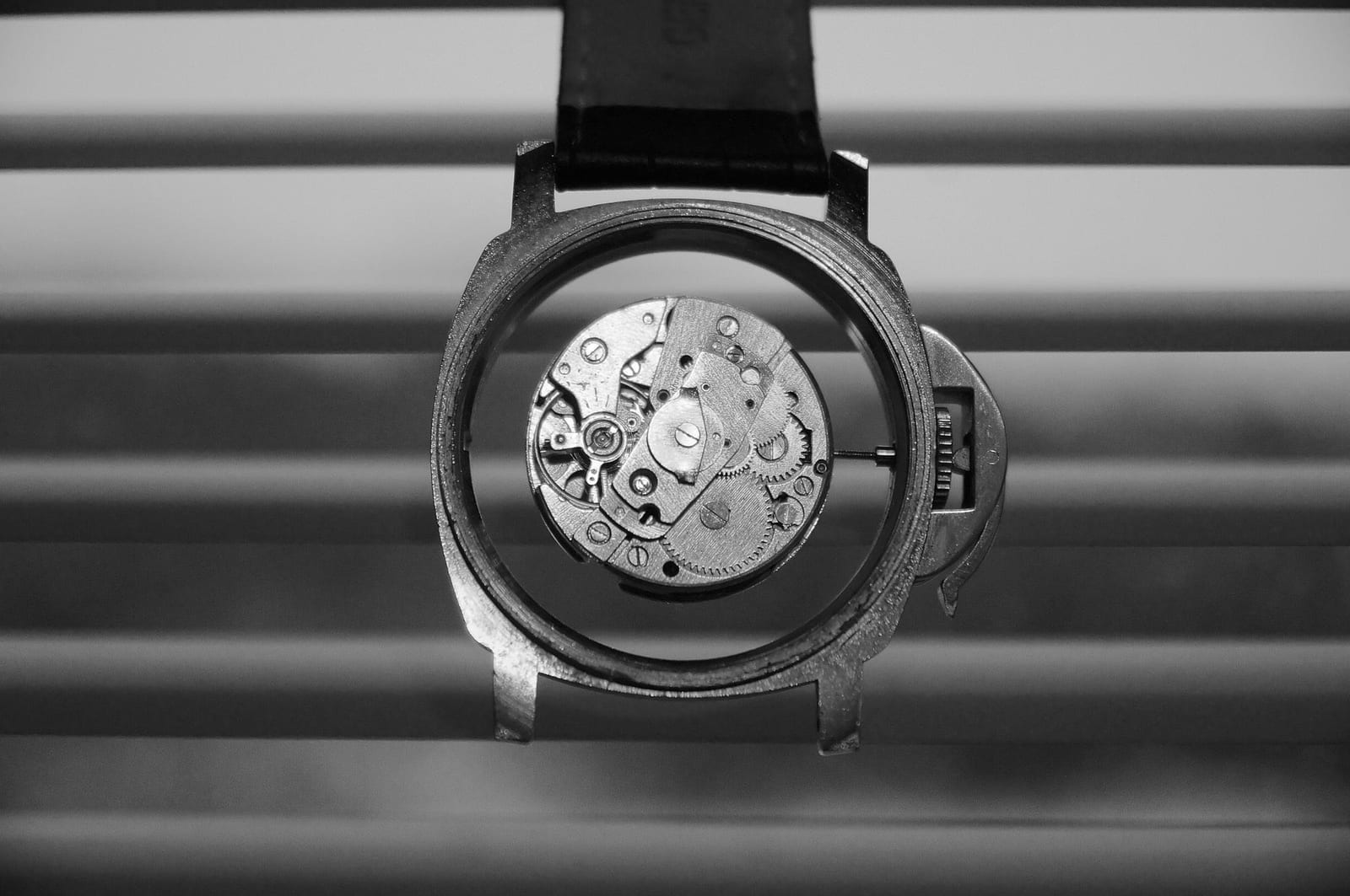Orologiaio al banco durante la sostituzione di un vetro zaffiro su una cassa da polso